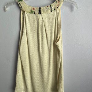 Shiny sleeveless cream colored top from Anthro